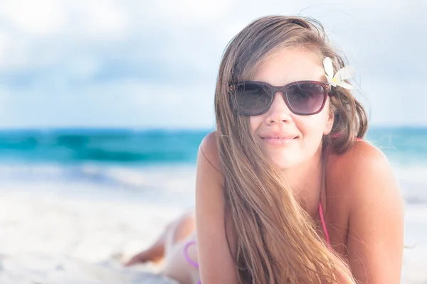Long haired young woman in bikini and sunglasses on tropical beach — Stock Photo, Image