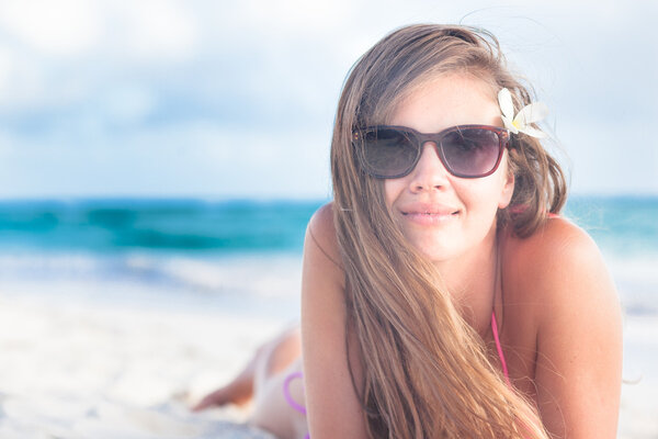 long haired young woman in bikini and sunglasses on tropical beach