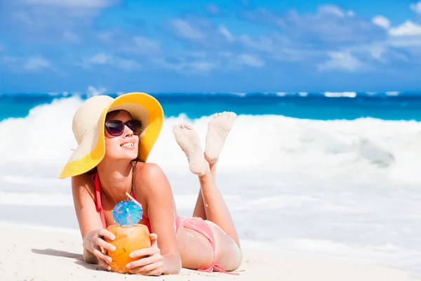 Vrouw in bikini met verse kokosnoot sap op tropisch strand — Stockfoto