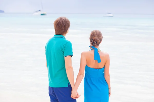 Achteraanzicht van paar hand in hand op een tropisch strand — Stockfoto