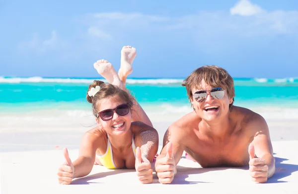 Felice giovane coppia sdraiata su una spiaggia tropicale nelle Barbados — Foto Stock