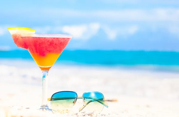 Vaso de cóctel refrigerado ron ponche y gafas de sol en la mesa cerca de la playa —  Fotos de Stock