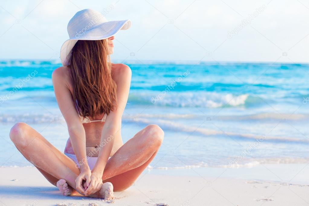 long haired girl in bikini and hat on tropical caribbean beach