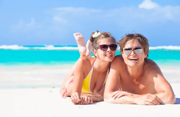 Felice giovane coppia sdraiata su una spiaggia tropicale nelle Barbados — Foto Stock