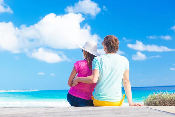 Vista trasera de una pareja sentada en una playa tropical en Barbados —  Fotos de Stock