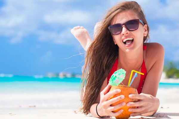 Jovem mulher em maiô e chapéu de palha em óculos de sol com coco na praia — Fotografia de Stock