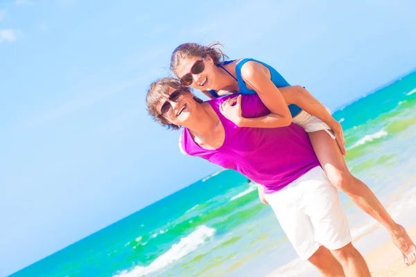 Bild på lyckliga par i solglasögon på stranden — Stockfoto