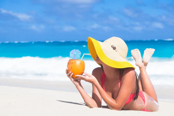 Vrouw in bikini met verse kokosnoot sap op tropisch strand — Stockfoto