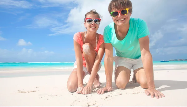 Primer plano de feliz joven pareja caucásica en gafas de sol sonriendo en la playa —  Fotos de Stock