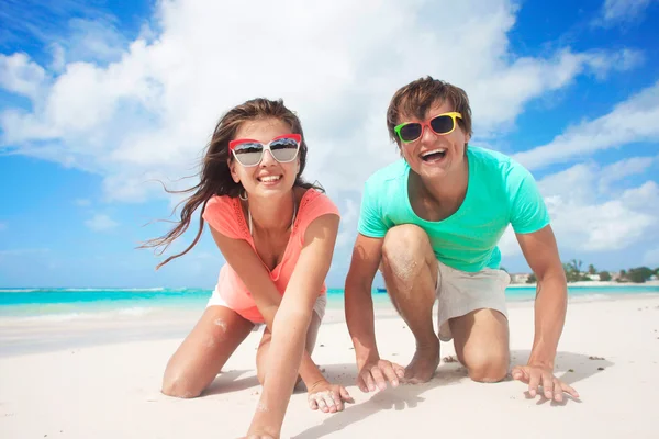 Closeup of happy young caucasian couple in sunglasses smiling on beach — Stock Photo, Image