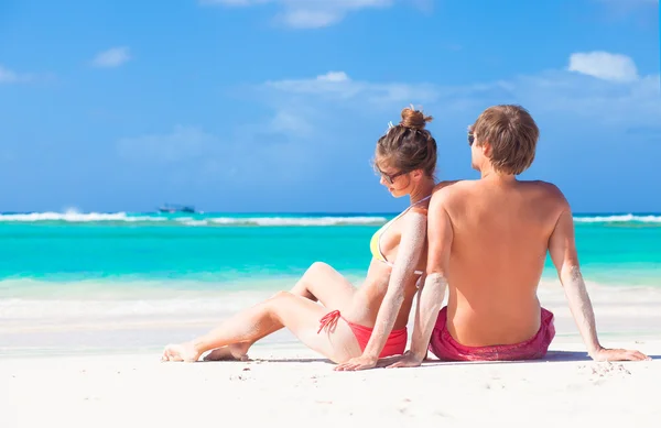 Achteraanzicht van paar zittend op een tropisch strand in Barbados Rechtenvrije Stockafbeeldingen