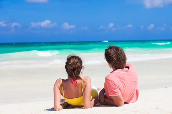 Vue arrière du jeune couple heureux en vêtements lumineux couché sur la plage — Photo