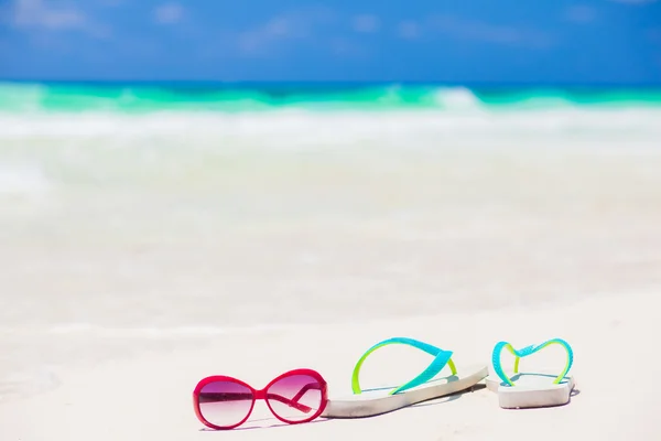 Klapki i okulary na tropikalnej plaży z fal na tle — Zdjęcie stockowe