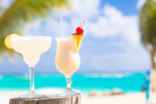 iki mükemmel kokteyller pina colada ve üst, plaj zemin üzerine kiraz ile margarita