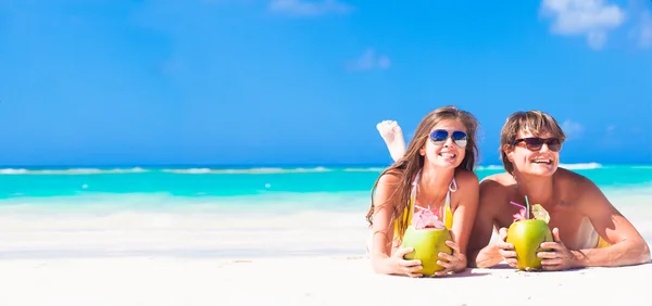 Young couple enjoying their time drinking two coconut cocktails — Stock Photo, Image