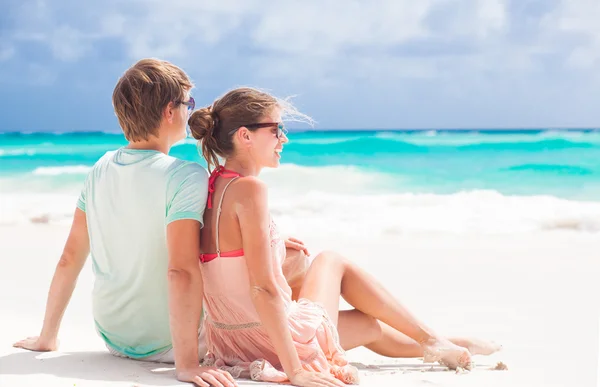 Vista trasera de pareja sentada en la playa —  Fotos de Stock