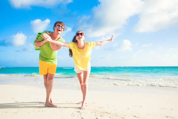 Foto de casal feliz em óculos de sol se divertindo na praia — Fotografia de Stock