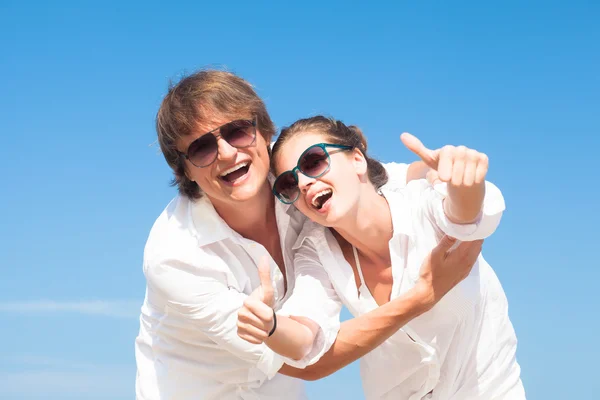 Happy young couple in white clothes having fun on tropical beach — Stock Photo, Image