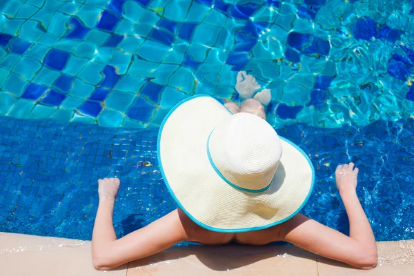 Jovem bela mulher em chapéu de palha relaxante na piscina spa — Fotografia de Stock