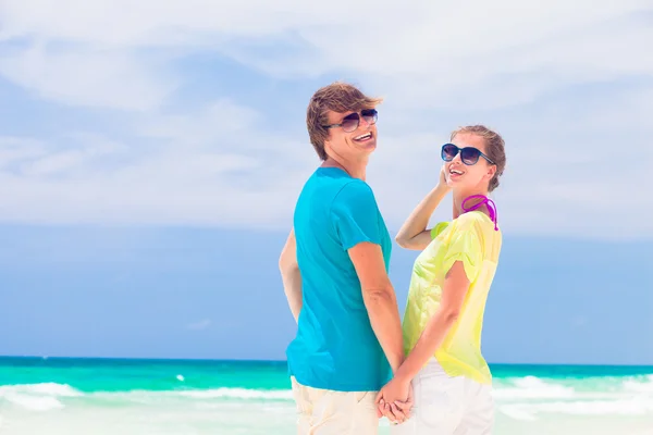 Вид сзади счастливой пары в солнцезащитных очках на пляже — стоковое фото