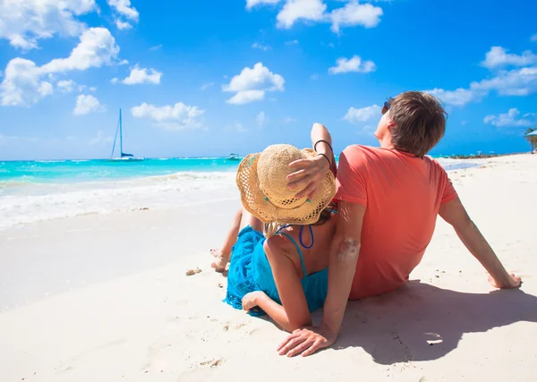 Felice giovane coppia seduta su una spiaggia tropicale nelle Barbados — Foto Stock