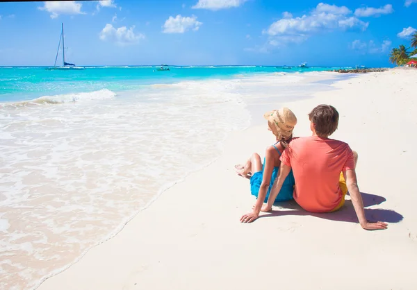 Gelukkige jonge paar zittend op een tropisch strand in Barbados — Stockfoto