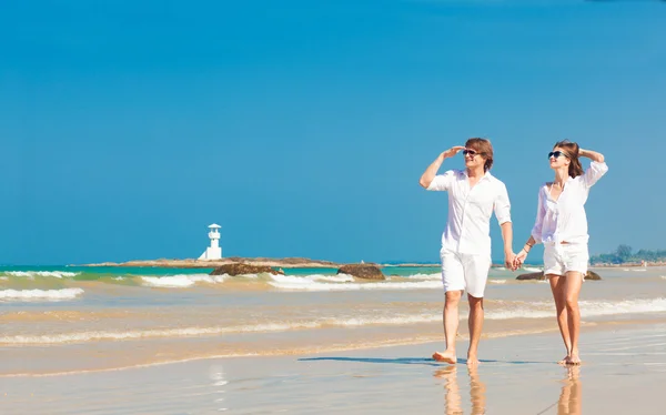 Boldog fiatal pár szórakozik a tropical beach fehér ruhát — Stock Fotó