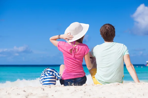 Вид сзади пары, сидящей на пляже — стоковое фото