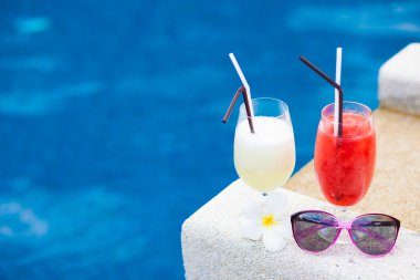 iki kadeh kokteyl ve güneş gözlüğü havuzu yakınlarında