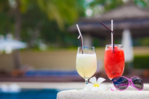 Two glasses of cocktails and sunglasses near pool — Stock Photo, Image