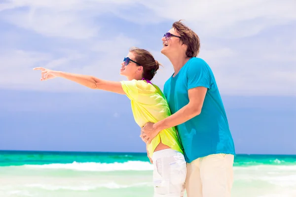 Back view of happy couple in sunglasses on the beach — Stock Photo, Image
