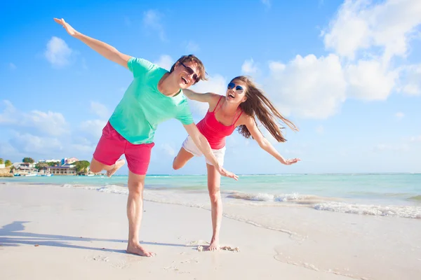 Вид сзади на счастливую молодую пару на пляже — стоковое фото