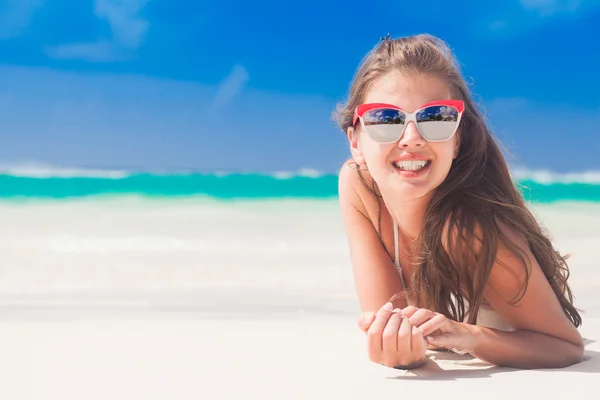 Mulher de biquíni e óculos de sol vermelhos deitada na praia tropical — Fotografia de Stock