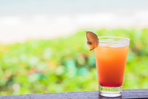 Фото свіжого фруктового коктейлю на тропічному пляжі — стокове фото
