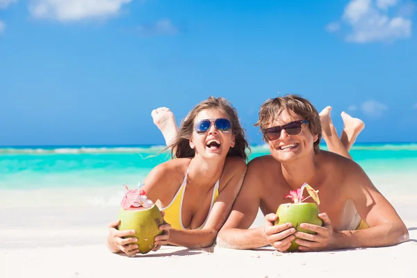 Pareja acostada en una playa tropical en Barbados y bebiendo un cóctel de coco —  Fotos de Stock