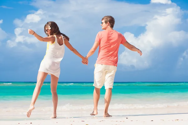 Vista posteriore di romantica giovane coppia che si tiene per mano sulla spiaggia Fotografia Stock