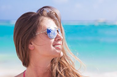 half face portrait of long haired beautiful woman in sunglasses at beach