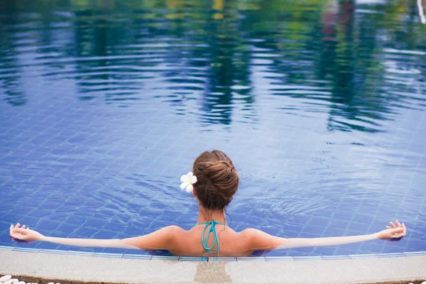 Visão traseira da bela jovem na piscina de luxo — Fotografia de Stock