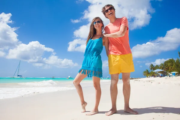 Closeup of happy young caucasian couple in sunglasses smiling at beach — Stock Photo, Image