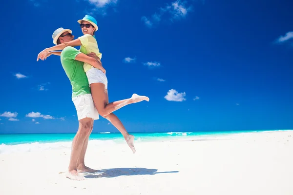 Casal em roupas brilhantes se divertindo na praia tropical — Fotografia de Stock