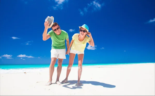 Casal em roupas brilhantes se divertindo na praia tropical — Fotografia de Stock