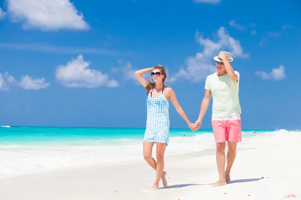 Romantiska par i ljusa kläder njuter solig dag på tropical beach — Stockfoto