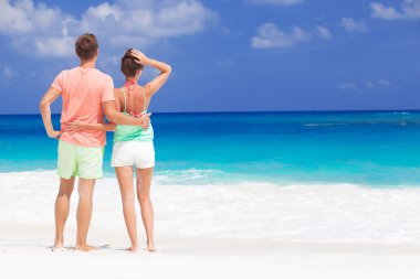 İki parlak kıyafetleri tropikal kumsalda eğleniyor sonra