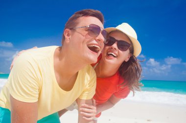 İki parlak kıyafetleri tropikal kumsalda eğleniyor sonra