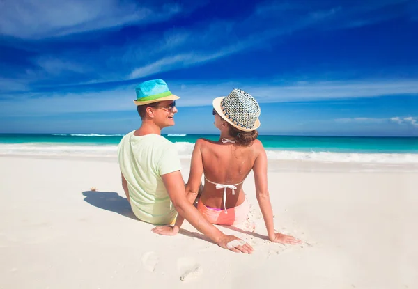 Romantiska par i ljusa kläder njuter solig dag på tropical beach — Stockfoto