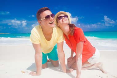 İki parlak kıyafetleri tropikal kumsalda eğleniyor sonra