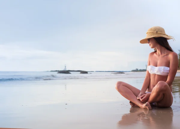 열 대 해변에서 저녁에 그녀의 시간을 즐기는 비키니와 밀 짚 모자에 젊은 여자 — 스톡 사진