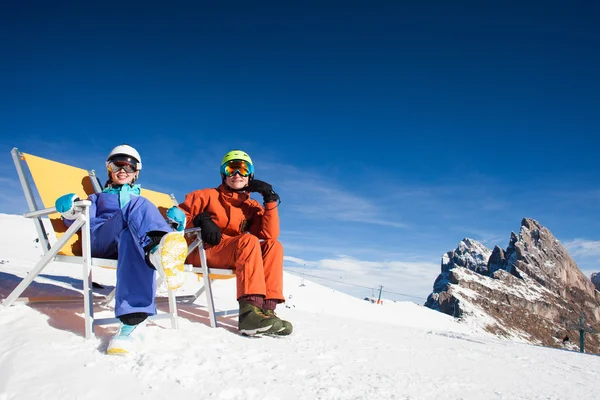 Två snowboardåkare på toppen av berget har roligt sitter på stol schäslong — Stockfoto