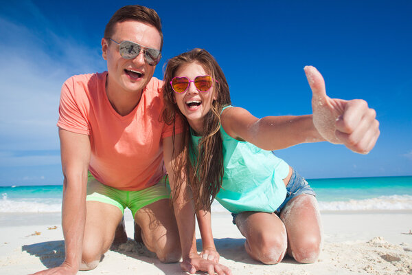 Couple in bright clothes having fun at tropical beach