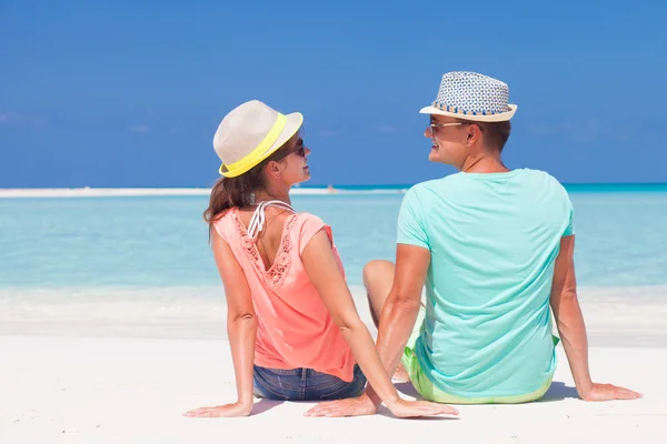 Vista trasera de pareja romántica en ropa brillante disfrutando de un día soleado en la playa tropical —  Fotos de Stock